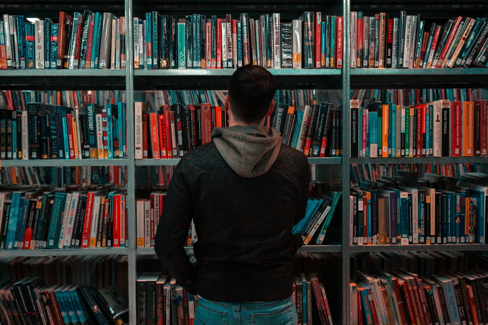 Man standing in front of a library bookcase