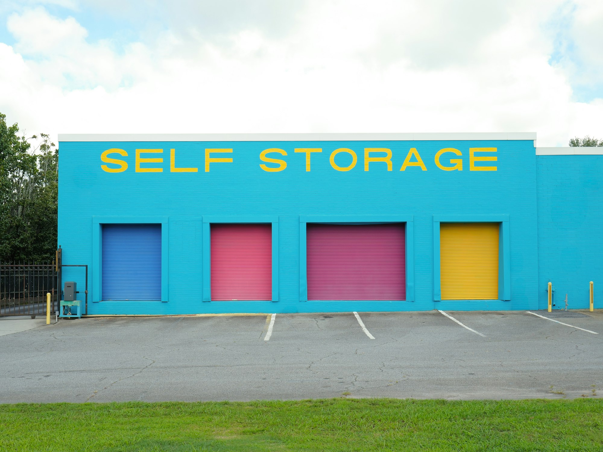 Brightly colored self storage building with four doors